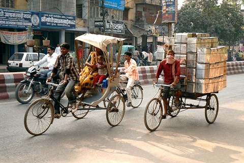 Framed People and cargo move through streets via rickshaw, Varanasi, India Print