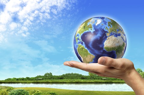 Framed Human Hand Holding Earth Globe with a Green Landscape Background Print