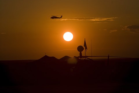 Framed UH-60 Blackhawk Flies Over Camp Speicher Airfield at Sunset Print