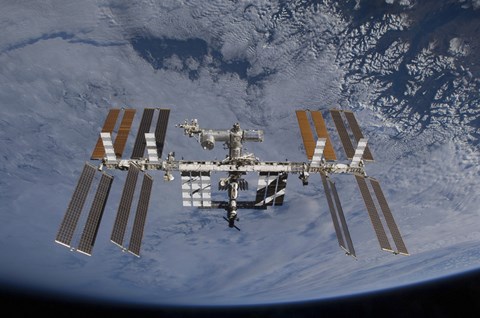 Framed International Space Station set against the background of a cloud covered Earth Print