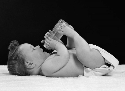 Framed 1950s Baby Lying On Back Drinking From Bottle Print