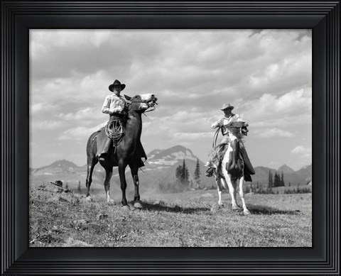 Framed Pair Of Cowboys On Horseback At Glacier Fifty Mountain Camp Print