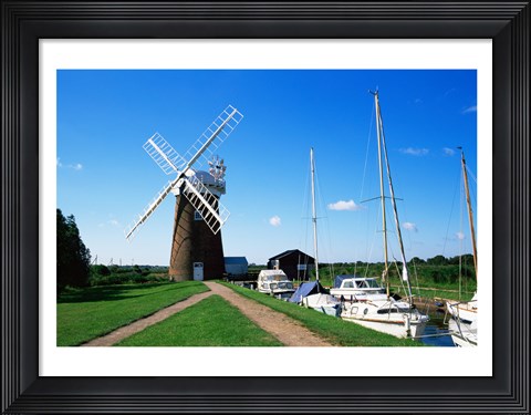 Framed Boat moored near a traditional windmill, River Ant, Norfolk Broads, Norfolk, England Print