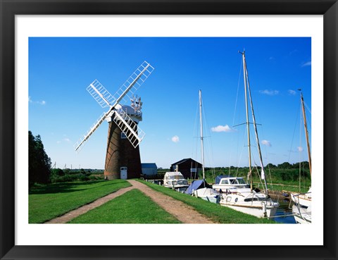 Framed Boat moored near a traditional windmill, River Ant, Norfolk Broads, Norfolk, England Print