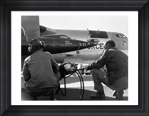 Framed Rear view of two men crouching near fighter planes, X-15 Rocket Research Airplane, B-52 Mothership Print