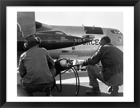 Framed Rear view of two men crouching near fighter planes, X-15 Rocket Research Airplane, B-52 Mothership Print