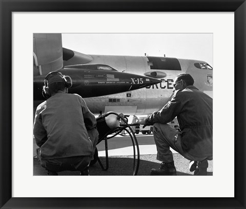 Framed Rear view of two men crouching near fighter planes, X-15 Rocket Research Airplane, B-52 Mothership Print