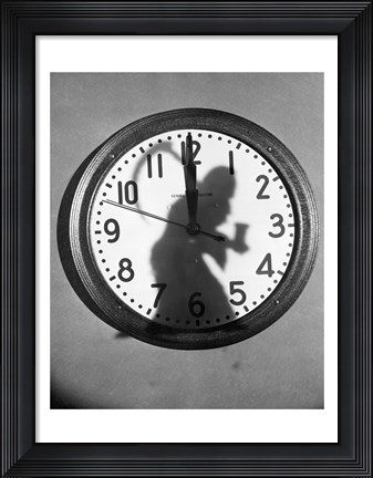 Framed Close-up of the shadow of a person carrying a scythe on a clock Print