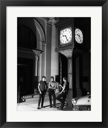 Framed Young men standing below clock at night Print