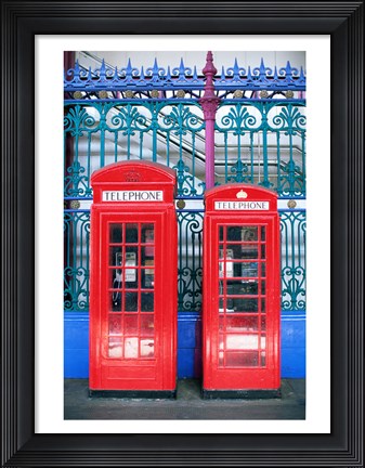 Framed Two telephone booths near a grille, London, England Print