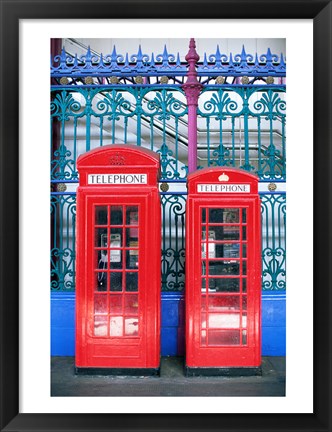 Framed Two telephone booths near a grille, London, England Print