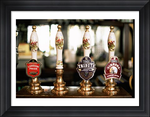 Framed Close-up of beer tap handles in a bar, London, England Print