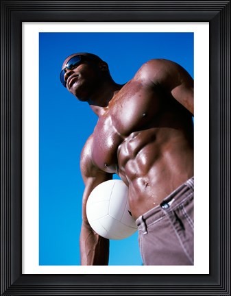 Framed Low angle view of a young man holding a volleyball Print
