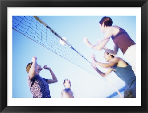 Framed Low angle view of two young couples playing beach volleyball Print