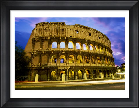 Framed Low angle view of the old ruins of an amphitheater lit up at dusk, Colosseum, Rome, Italy Print