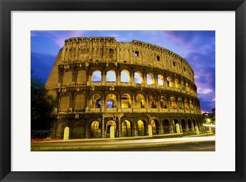 Framed Low angle view of the old ruins of an amphitheater lit up at dusk, Colosseum, Rome, Italy Print