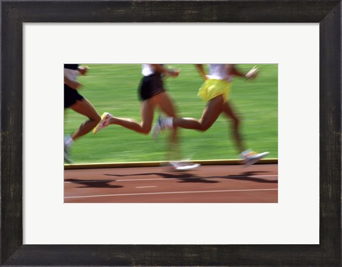 Framed Low section view of male athletes running on a running track Print