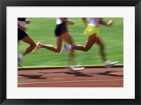 Framed Low section view of male athletes running on a running track Print