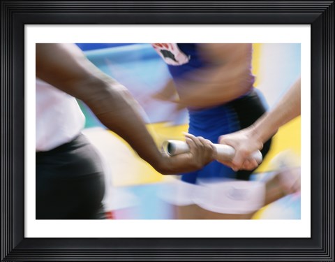 Framed Mid section view of runners exchanging baton at a relay race Print