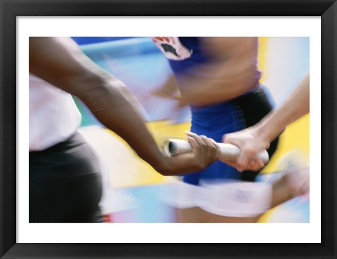 Framed Mid section view of runners exchanging baton at a relay race Print