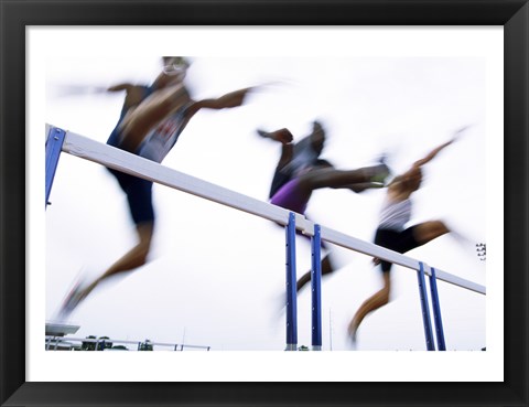 Framed Low angle view of three men jumping over a hurdle Print