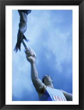 Framed Low angle view of runners passing a baton in a relay race Print