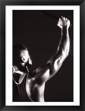 Framed Male runner holding up a relay baton Print