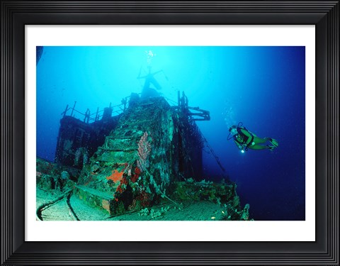 Framed Scuba diver watching a shipwreck underwater Print