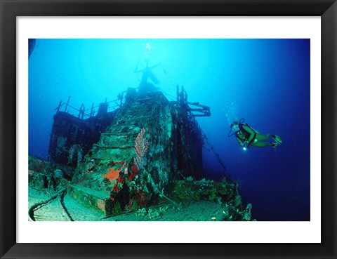 Framed Scuba diver watching a shipwreck underwater Print