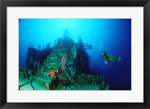 Framed Scuba diver watching a shipwreck underwater Print