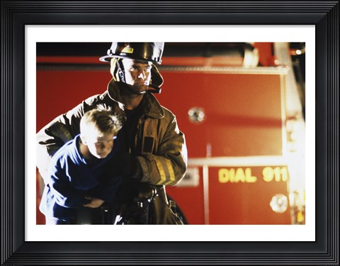 Framed Close-up of a firefighter carrying a boy Print