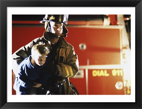 Framed Close-up of a firefighter carrying a boy Print