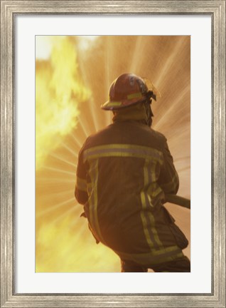 Framed Rear view of a firefighter extinguishing a fire Print
