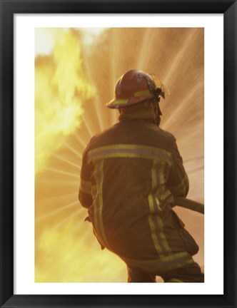 Framed Rear view of a firefighter extinguishing a fire Print