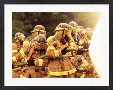Framed Group of firefighters spraying water with a fire hose Print