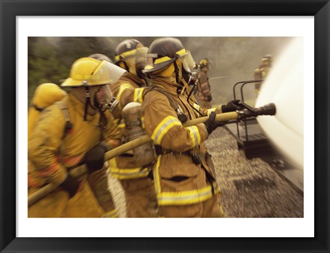 Framed Side profile of a group of firefighters holding water hoses Print