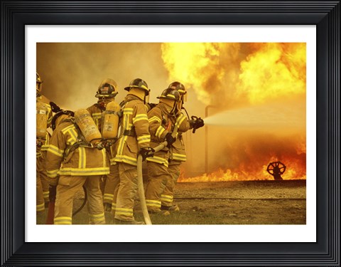 Framed Rear view of a group of firefighters extinguishing a fire Print