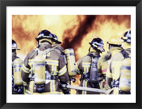 Framed Rear view of a group of firefighters holding water hoses Print