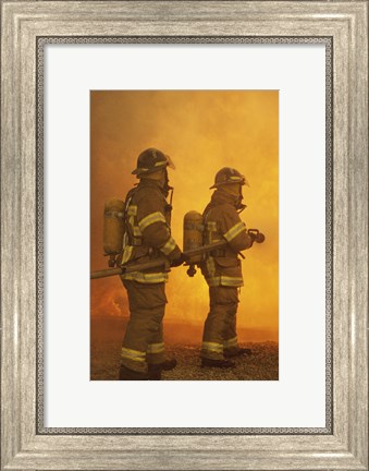 Framed Rear view of two firefighters extinguishing a fire Print