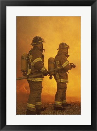 Framed Rear view of two firefighters extinguishing a fire Print