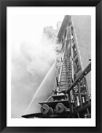 Framed Fire engine with ladder up burning building Print