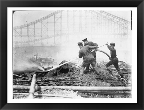 Framed Three firefighters extinguishing a fire Print