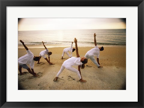 Framed Group of people performing yoga on the beach Print