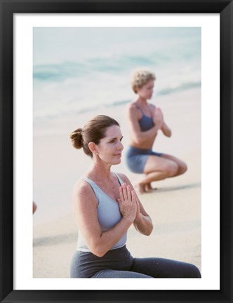 Framed Young woman and a mid adult woman meditating on the beach Print