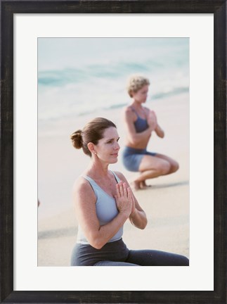 Framed Young woman and a mid adult woman meditating on the beach Print