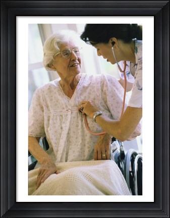 Framed Female nurse checking a female patient&#39;s heartbeat Print