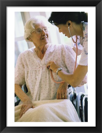 Framed Female nurse checking a female patient&#39;s heartbeat Print