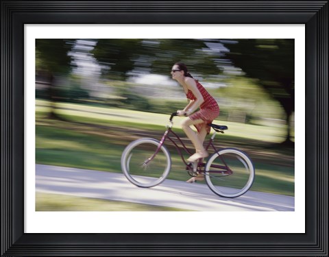 Framed Side profile of a young woman riding a bicycle Print
