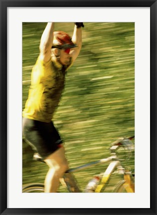 Framed Young man sitting on a bicycle with his arms raised Print