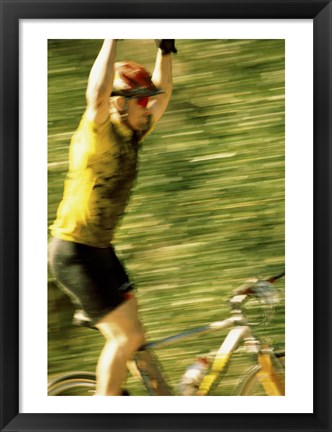 Framed Young man sitting on a bicycle with his arms raised Print